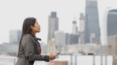 Businesswoman looking out at London city skyline