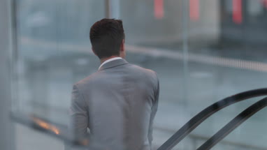 Businessman travelling down escalator