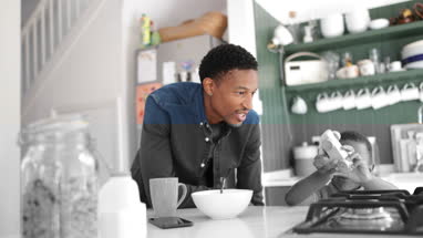 Boy playing whilst eating breakfast