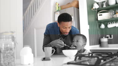 Dad helping son with breakfast