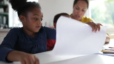 African American holding up school work proudly