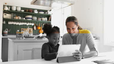 Mother teaching Daughter how to use digital tablet