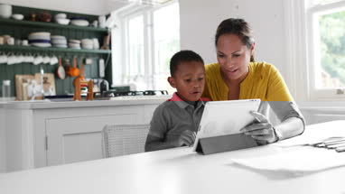 Mother teaching Son how to use digital tablet