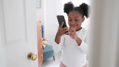 Girl being supervised playing on smartphone 