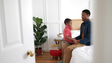 Father helping son dress in the morning