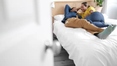 Couple lying on bed together relaxing