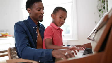Father teaching Son to play the piano