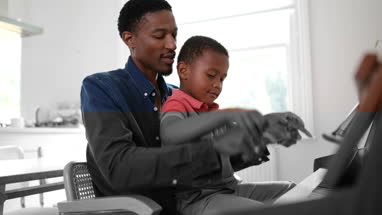 Father teaching Son to play the piano