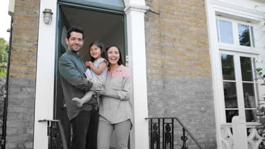 Family standing in doorway of home