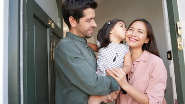 Family standing in doorway of home