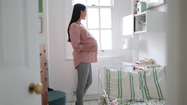 Pregnant woman standing in nursery room