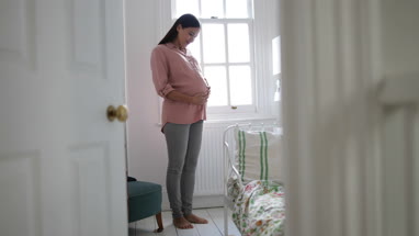 Pregnant woman standing in nursery room