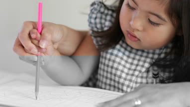 Girl learning how to write with Mother’s help