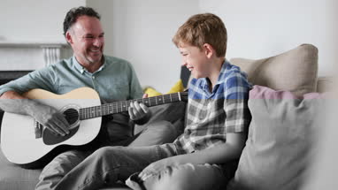 Father showing Son he can play guitar