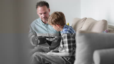 Father giving son a VR headset