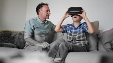 Boy putting on a VR headset game at home