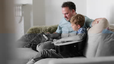 Father and Son watching a video tutorial on guitar playing