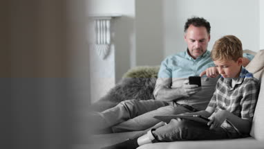 Father and Son individually using technology
