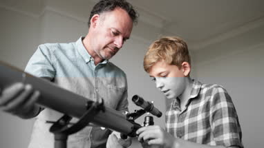 Father teaching Son how to use a telecsope