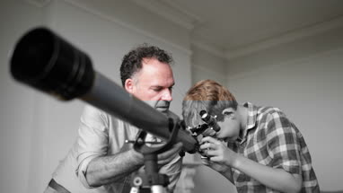 Father and Son using a telescope