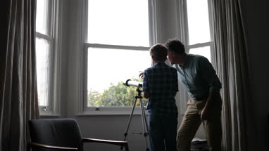 Father and Son looking at view with a telescope
