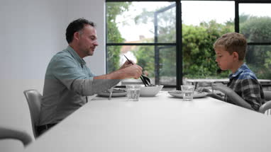 Father giving his Son some salad with a meal