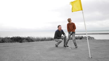 Father watching Son play golf