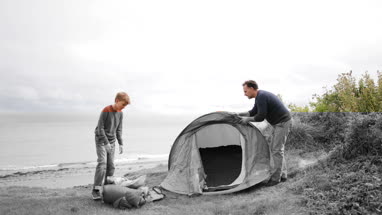 Father and Son putting up a tent together