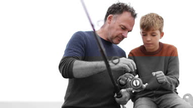 Father and Son setting up a fishing rod together