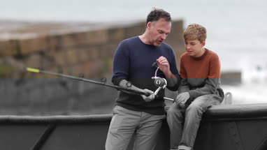 Father and Son sitting on boat getting ready for fishing trip