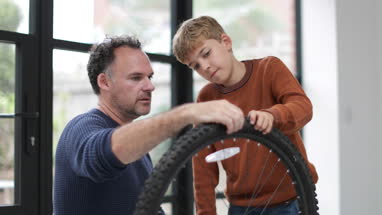 Father teaching Son how to care for his bicycle