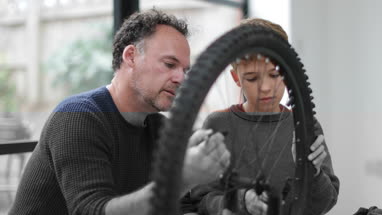 Father teaching Son how to care for his bicycle