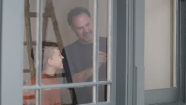 Father teaching Son how to decorate window