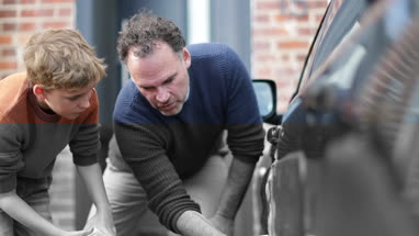 Son helping Father wash car