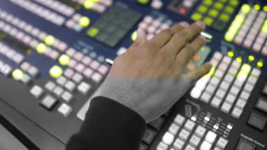 Close-up of hand operating TV control room technology