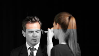 TV presenter having make-up applied on set