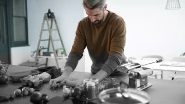 Adult male rolling pasta dough