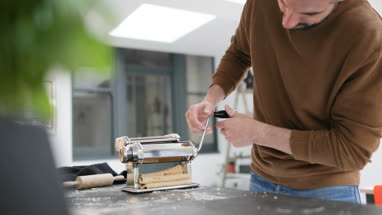 Adult male using a pasta machine