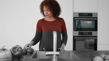 African American female washing tomatoes