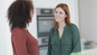 Friends socialising in a kitchen whilst cooking