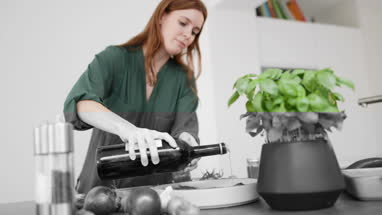 Adult female drizzling olive oil over a dish