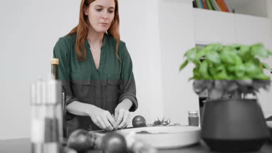 Adult female adding fresh basil to a dish