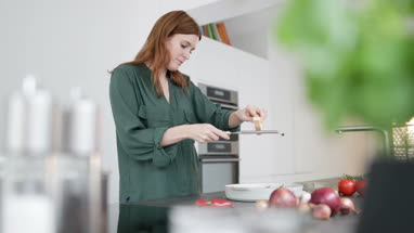 Adult female grating parmesan over a dish