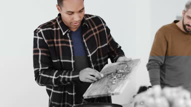 Adult male putting ingredients into a pan