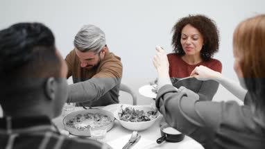 Female serving friends salad at a meal
