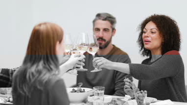 Friends clinking glasses over a meal together
