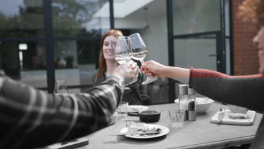 Friends eating a meal and drinking wine outdoors