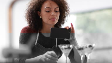 Female food blogger posting a photo with smartphone
