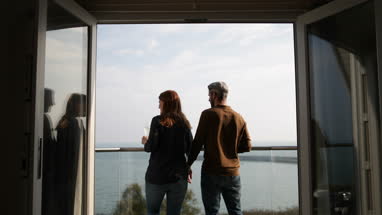 Couple enjoying view from balcony of sea
