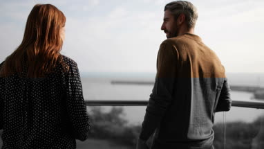Couple enjoying view from balcony of sea